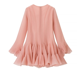 Detailed view of pink ruffled layered hem and textured chiffon fabric of the dress