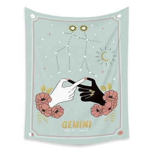 Macro shot of Gemini constellation tapestry with soft blue fabric and floral astrology art