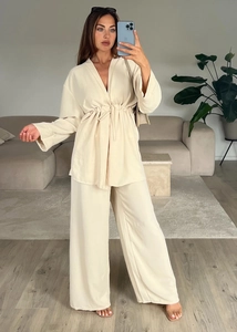 Detailed full-body mirror selfie showing a beige V-neck tie-waist top and wide-leg trousers