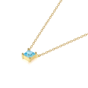Macro shot of a light blue square-cut gemstone on a delicate gold sterling silver chain