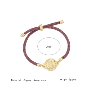 Macro detail of purple braided Virgin Mary bracelet with 18K gold-plated micro-pave charm