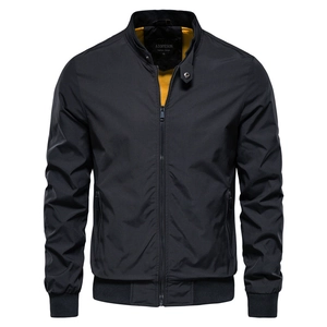 Detail of men's black stand collar jacket with vibrant yellow lining and zip pockets