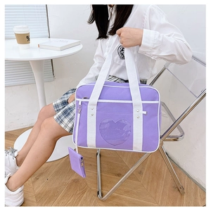 Detail of purple JK uniform bag featuring transparent heart window and small coin purse