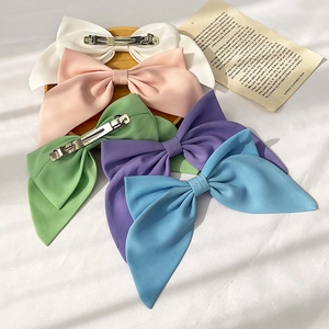 Flat lay of colorful fabric bow hair clips in white, pink, green, purple and blue