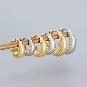 Macro shot showing gold and silver S925 sterling silver textured hoop earrings in detail