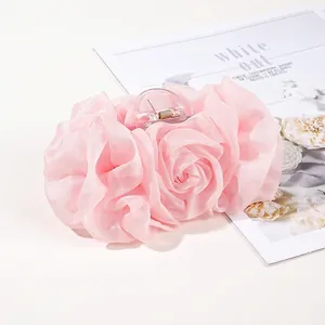 Detail of pink chiffon rose hair claw clip with transparent resin and gold spring
