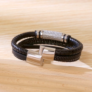 Detailed close-up of multilayer black braided leather bracelet with silver magnetic clasp