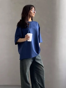 Dettaglio della t-shirt in cotone blu reale con vestibilità ampia e spalle scese