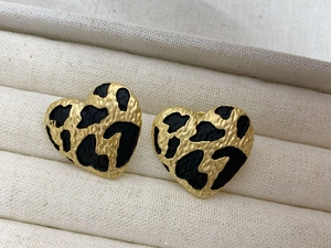 Close-up of heart-shaped leopard print earrings with gold metal base and texture