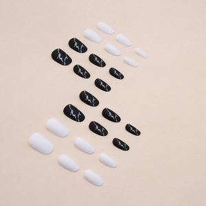 Elegant black marble and white oval press-on nails set arranged in a minimalist S-curve pattern