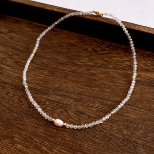 Close-up of baroque pearl and moonstone beads on a seaside style necklace