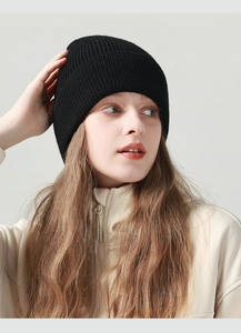Detaillierte Strickstruktur einer schwarzen minimalistischen Beanie-Mütze an einem Model