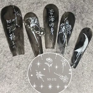 Detail of dark gothic nail stickers with lily motifs and star designs on long false nails