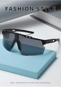 Detail of matte black cycling sunglasses with grey-blue large wrap lens on a stand