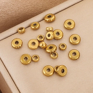 Golden stainless steel abacus beads with diverse textures on silk fabric backdrop