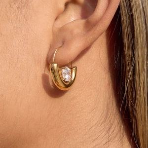 Classic 18K gold plated U-shaped earrings with oval zircon gemstone worn by a model