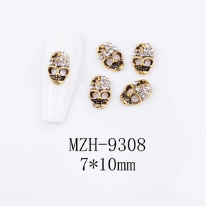 Macro detail of 7x10mm skull nail charms with rhinestones and vintage gold base