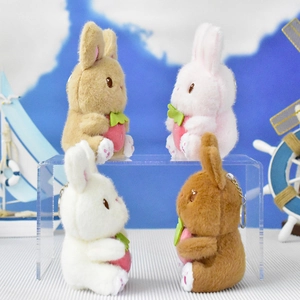 Side view of four colorful plush bunny keychains holding strawberries for bag decoration