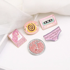 Pink enamel zinc alloy brooch set with creative slogans on a white display tray