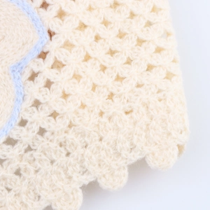 Close-up of sweet crochet knit crop top in cream white with delicate scalloped edges