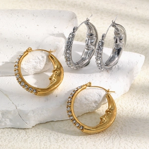 Detailed view of gold and silver moon face hoop earrings with sparkling cubic zirconia stones