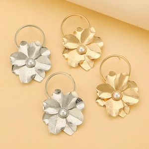 Detail of vintage flower earrings with layered petals and white pearl center