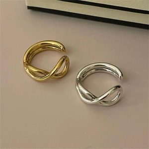 Macro detail of minimalist 925 sterling silver crisscross rings in gold and silver finish