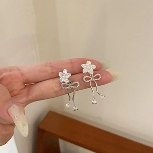 Elegant silver flower earrings with cubic zirconia bow and teardrop fringe detail