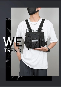 Close-up of black tactical vest bag showing multiple pockets and reflective safety strips