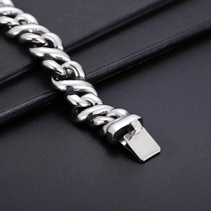 Macro detail of high-polish stainless steel Cuban chain bracelet with a secure fold-over clasp