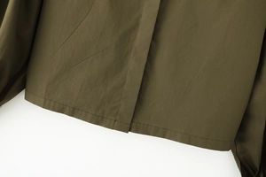 Detail of army green cotton poplin shirt hem showing precise double stitching texture
