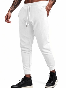 Detail of white waffle knit texture and adjustable drawstring waistband on men's casual pants