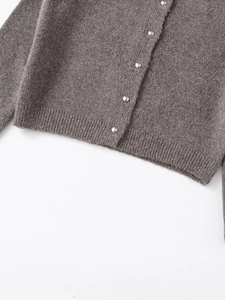 Detailansicht des dunkelgrauen Strick-Cardigans mit silbernen Metallknöpfen am Saum