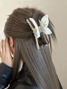 French butterfly hair claw clip with marble texture shown on blonde hair