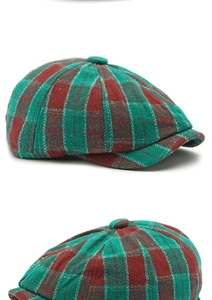 Detail of red and green plaid newsboy cap showing wool blend texture and button top