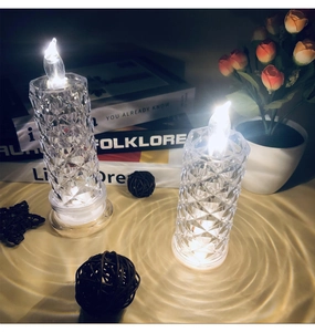 Detail of crystal LED candle light with warm white glow on a romantic table setting