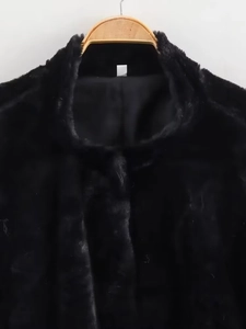 Detailed close-up of premium black faux fur jacket collar on a wooden hanger