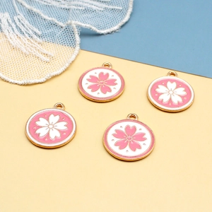 Pink and white cherry blossom round alloy charms with gold borders on lace background