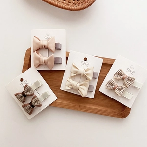 Detail of fabric bow hair clips in plaid and satin textures on display cards