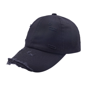 Detail of distressed ripped edges on a vintage black cotton twill baseball cap