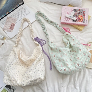 Détail de sacs bandoulière à motifs floraux et texture en tissu seersucker gaufré