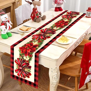 Close-up of Christmas table runner featuring poinsettia, bells, and red-black plaid borders