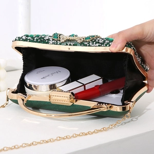 Elegant emerald green rhinestone clutch bag with gold handle showing cosmetic storage capacity