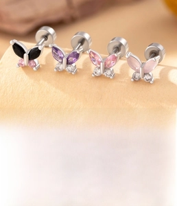 Macro detail of butterfly ear studs in silver titanium steel with colorful zircon stones