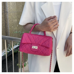 Detailed view of magenta quilted texture bag with gold chain strap and metallic lock