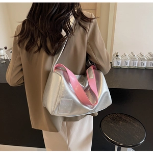 Silver metallic Boston bag with pink strap detail shown on a model's shoulder