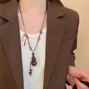 Vintage wooden gourd pendant necklace with ethnic beads on a brown cord necklace
