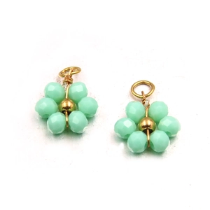 Close-up of mint green flower pendants with gold metal and faceted glass crystal beads