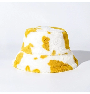 Detailed view of yellow and white cow print plush bucket hat with soft faux fur texture