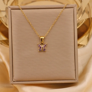 Detail of 18K gold plated butterfly pendant necklace with purple zircon inlay on silk
